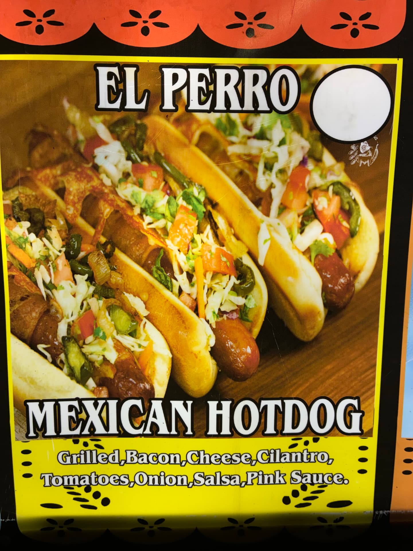 Mexican hotdogs topped with bacon, cheese, vegetables, and sauce